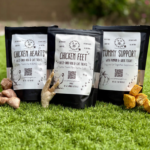 Three packages of pet food on grass with visible ingredients.
